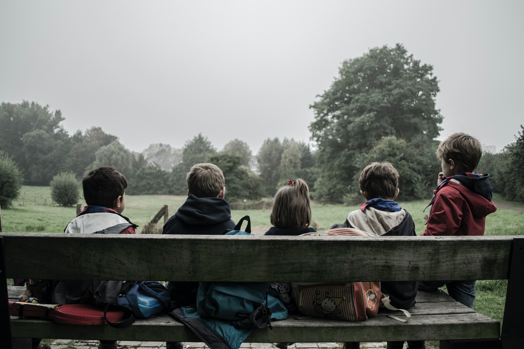 Children sit on a bench (credit Piron Guillaume via Unsplash)