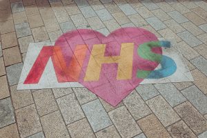 An NHS heart logo on the pavement