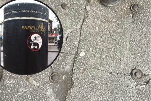 Bolts in the pavement show where a litter bin has been removed in Grange Park