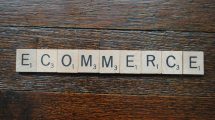 scrabble letters on a wood table spelling the word e-commerce