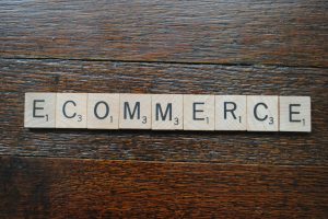 scrabble letters on a wood table spelling the word e-commerce