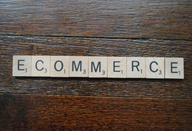 scrabble letters on a wood table spelling the word e-commerce