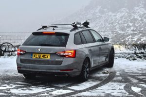 A car parked overlooking a snowy hillside view