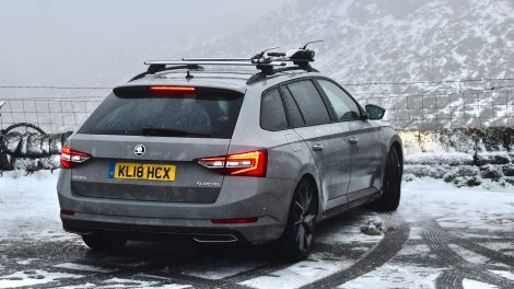 A car parked overlooking a snowy hillside view