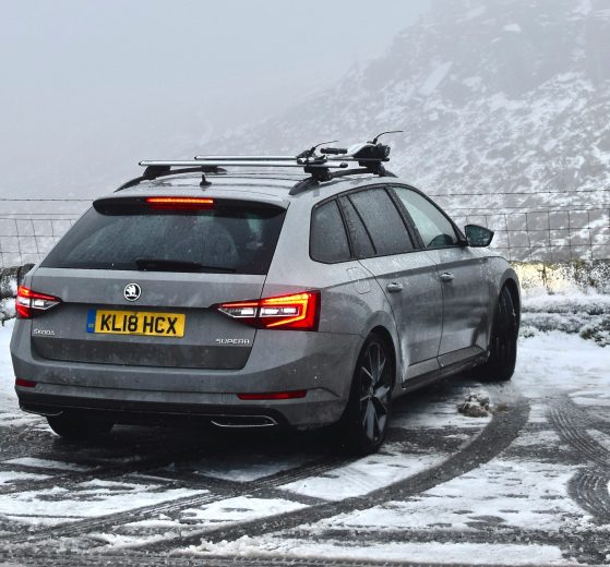 A car parked overlooking a snowy hillside view