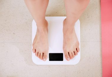 a pair of feet stand on some bathroom scales