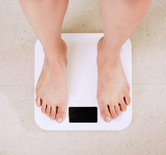 a pair of feet stand on some bathroom scales