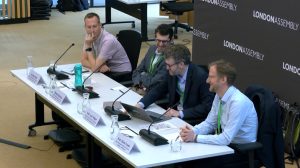 A row of four men sitting behind a desk
