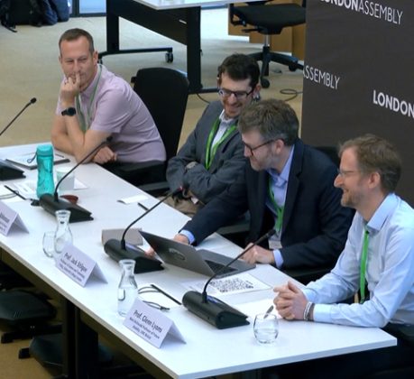 A row of four men sitting behind a desk