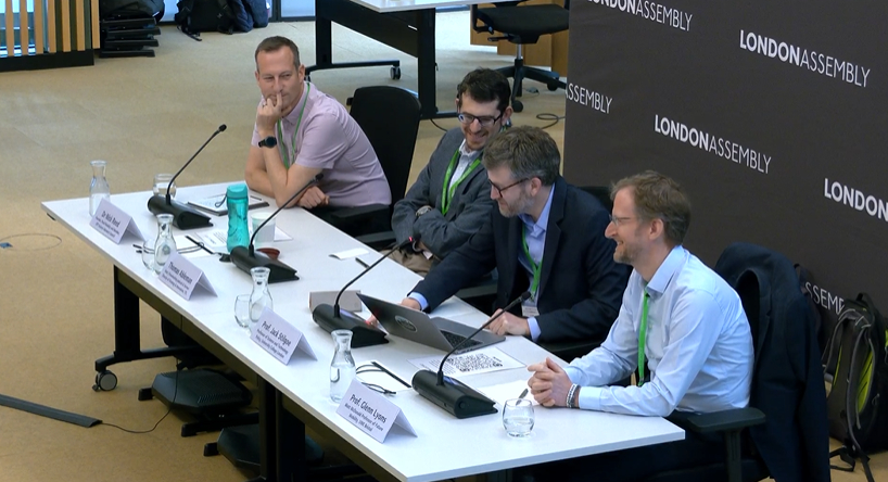 A row of four men sitting behind a desk
