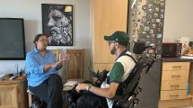 A woman sitting on a chair talking to a man in a wheelchair