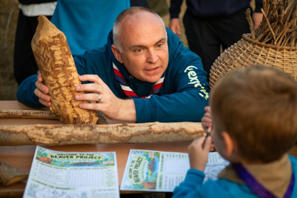 Scout leader and council cabinet member Andrew Thorp with a tree stump chomped by beavers (credit Enfield Council)