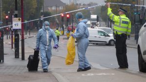 Detectives remove evidence from the crime scene in Hertford Road