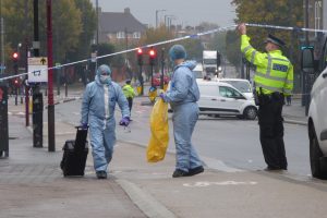 Detectives remove evidence from the crime scene in Hertford Road