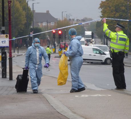 Detectives remove evidence from the crime scene in Hertford Road